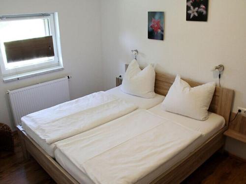 a bedroom with two beds with white sheets and a window at Holiday apartment Villa Sonja 