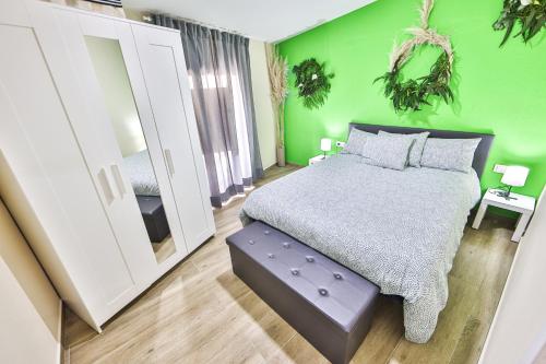 a green bedroom with a bed and a mirror at A Casa de Isaura in Camariñas