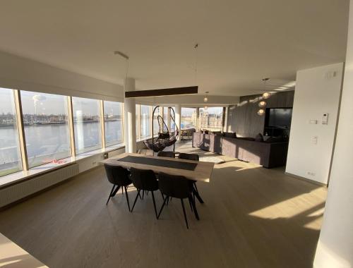 een keuken met een tafel en stoelen in een kamer met ramen bij Dreamloft in Antwerpen