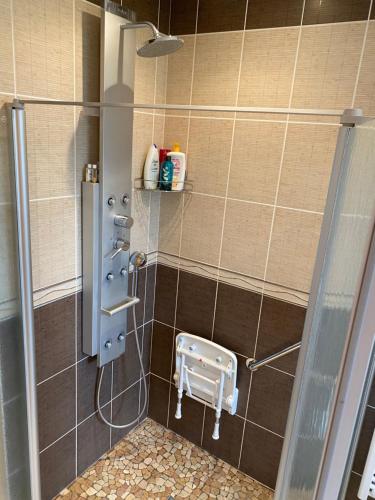 een badkamer met een douche met een kruk erin bij Villa Fransesca in Ban-sur-Meurthe-Clefcy