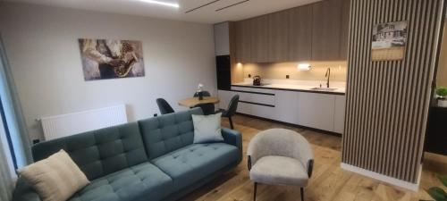 グニェズノにあるApartament,,Nuta''の青いソファとキッチンのあるリビングルーム