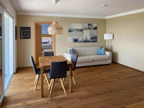 a living room with a table and a couch at Greim15 --- Apartment mit Fernsicht und Pool 50m2 in Greim