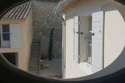 une fenêtre ronde donnant sur l'intérieur du bâtiment dans l'établissement Maison de Charme - l'Intimiste, à Caderousse