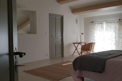 une chambre avec un lit, une table et une fenêtre dans l'établissement Maison de Charme - l'Intimiste, à Caderousse