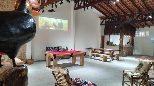 a room with a ping pong table and chairs at Pousada Dona Carmem Ubatuba in Ubatuba