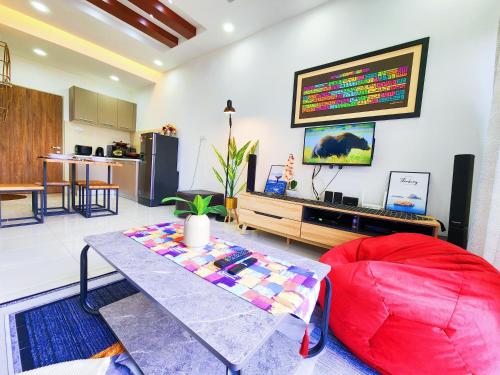 een woonkamer met een tafel en een rode bank bij Nilai Sepang, Oasis Blissful 3BR Fully Air-CON in Nilai