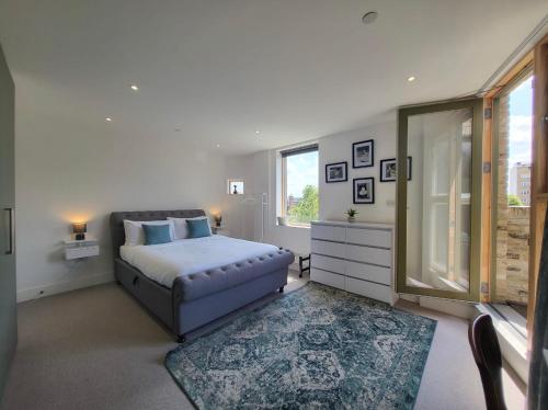 a white bedroom with a bed and a window at Central London penthouse apartment in London