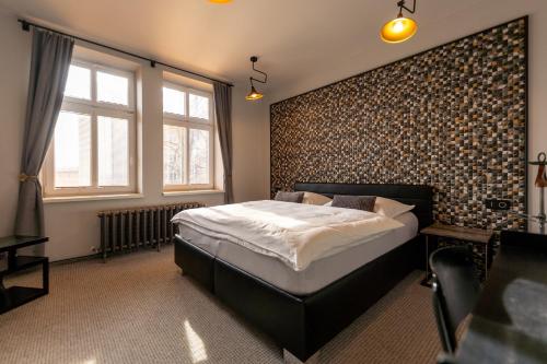 een slaapkamer met een bed in een kamer met een bakstenen muur bij Pension Padre in Ostrava