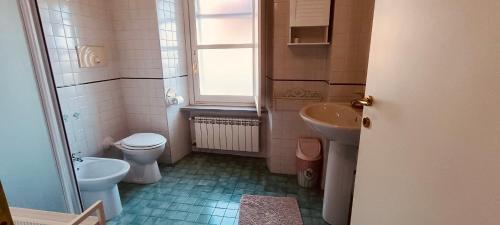a bathroom with a sink and a toilet and a window at Tormalina rosa presso La Bordona in Vignale