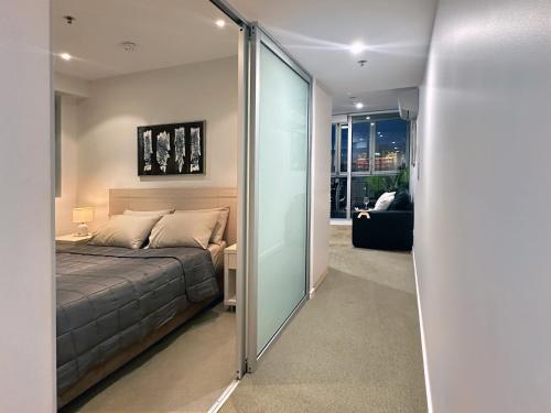 a bedroom with a bed and a sliding glass door at CBD Sky View Apartment in Adelaide
