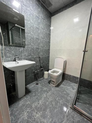 La salle de bains est pourvue d'un lavabo, de toilettes et d'une douche. dans l'établissement Mirvari city 2room, à Soumgaït