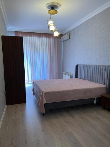 - une chambre avec un lit et une grande fenêtre dans l'établissement Mirvari city 2room, à Soumgaït