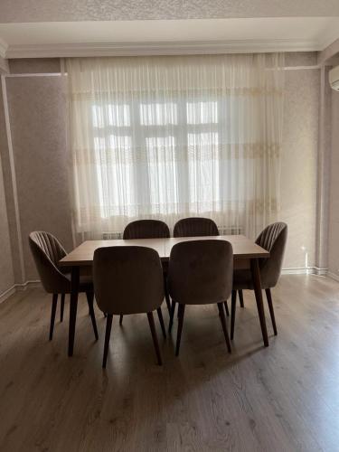 d'une salle à manger avec une table, des chaises et une fenêtre. dans l'établissement Mirvari city 2room, à Soumgaït