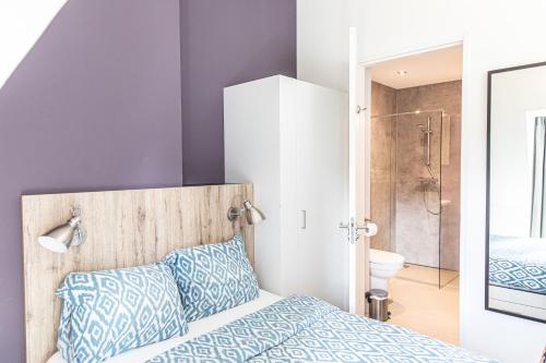 um quarto com uma cama e uma casa de banho com um chuveiro em JOINN! City Lofts Houten Utrecht em Houten