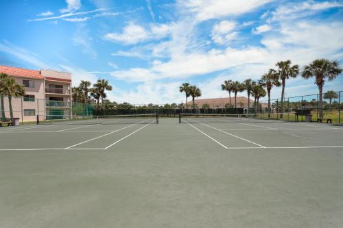 a tennis court with palm trees in the background at Ocean Village Club N16 in Saint Augustine
