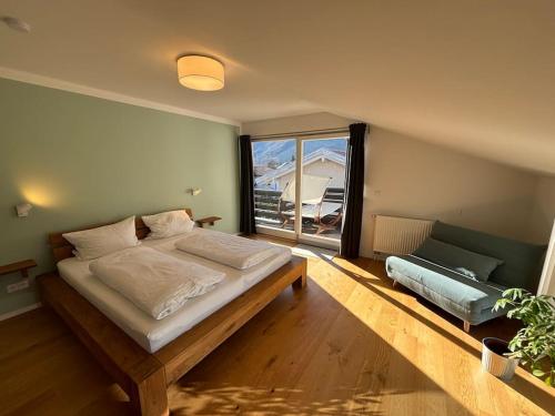 a bedroom with a bed and a large window at Fewo Bergblick Aschau im Chiemgau in Aschau im Chiemgau