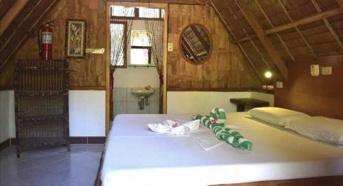 a bedroom with a large white bed in a room at Sulu Sunset Beach Resort in Nauhang