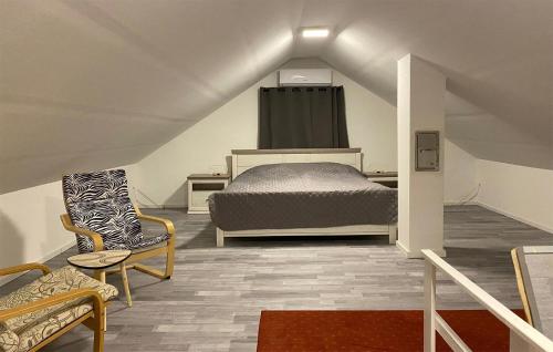 a bedroom with a bed and chairs in a attic at Amazing Home In Friedberg With Kitchen 