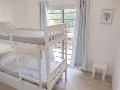 a white bunk bed in a room with a window at Amplio dúplex en Lomas con cochera in Lomas de Zamora