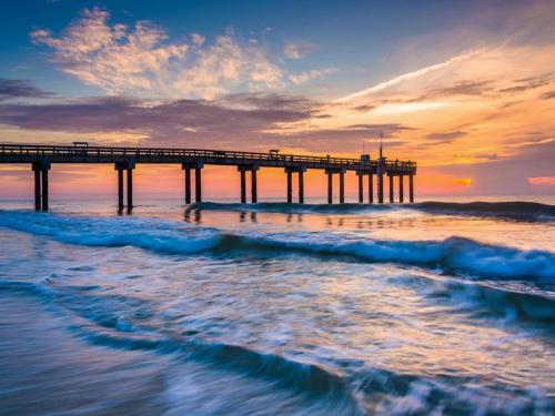 a pier on the beach with the ocean waves at Four Winds I-9T in Cedar Landing