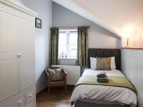 a bedroom with a bed and a window and a chair at Glanllyn Lodge in Llanuwchllyn