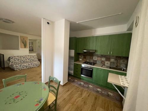 - une cuisine avec des armoires vertes et une table dans une pièce dans l'établissement B&B Madonna Carradori, à Offagna