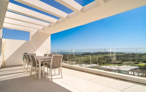 a balcony with a table and chairs and a large window at 3 Bedroom Amazing Apartment In Estepona in Estepona