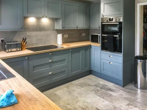a kitchen with blue cabinets and a counter at Quiet Ways in Portinscale