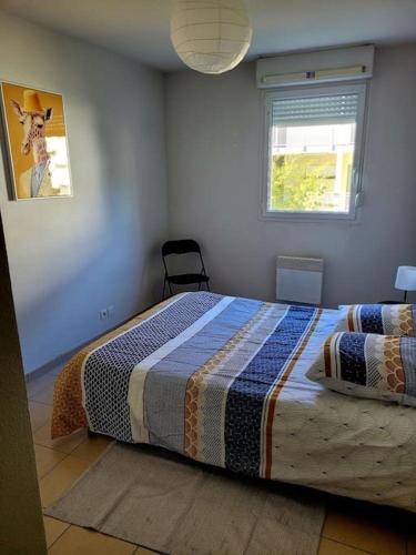 ein Schlafzimmer mit einem Bett mit einer Decke darauf in der Unterkunft T3 proche bus et tram in Angers