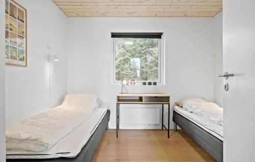Duas camas num quarto com uma secretária e uma janela em Lovely Home In Hadsund With Kitchen em Hadsund