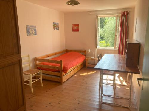 une chambre avec un lit, une table et une fenêtre dans l'établissement Gite des Noisettes à la porte de Saintes, à Chermignac