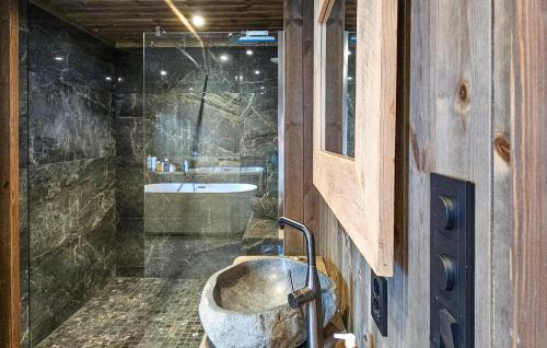 Gorgeous Home In Passebekk With Kitchen في Omholt: حمام مع حوض حجري وحوض استحمام