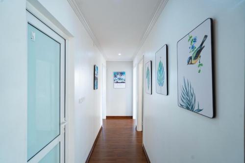 un couloir avec des murs blancs et des photos sur les murs dans l'établissement Three-bedroom house with sea view, à Hạ Long