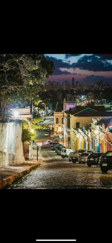a city at night with cars parked on a street at Ladeira de Olinda in Olinda