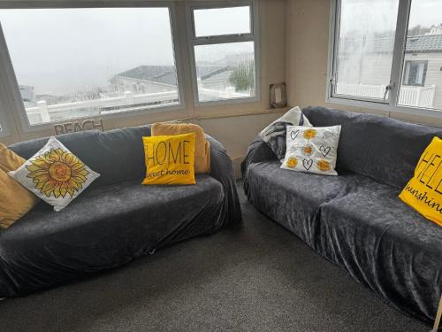 a living room with two couches with pillows on them at Devon Cliffs in Exmouth