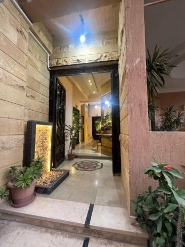 een ingang naar een gebouw met planten in een gang bij Nargesstar in Caïro