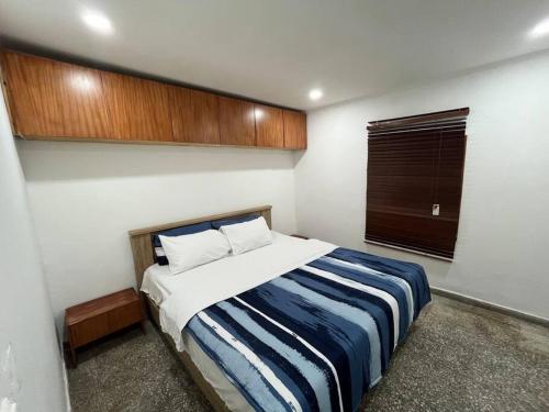 - une chambre dotée d'un lit avec une couverture bleue et blanche dans l'établissement Lx Apart in Sommerschield 2, à Maputo