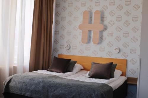 a bedroom with two beds and a cross on the wall at Hesehotelli Turku Linja-autoasema in Turku