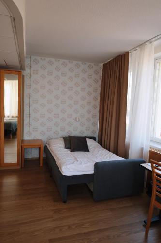a bedroom with a bed and a couch in it at Hesehotelli Turku Linja-autoasema in Turku