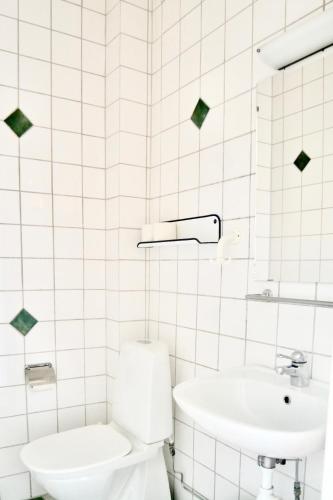 a white bathroom with a toilet and a sink at Hemmet B&B in Simrishamn