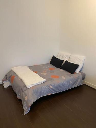 un letto con due cuscini e una coperta sopra di Charmant studio, 10 minutes d’Orly / 20 minutes de Paris a Wissous