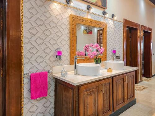 ein Badezimmer mit 2 Waschbecken und einem Spiegel in der Unterkunft Maison d'hôtes bon coin in Marrakesch