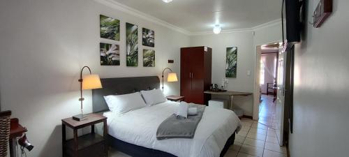 a bedroom with a large white bed in a room at Premiere Guesthouse in Bloemfontein
