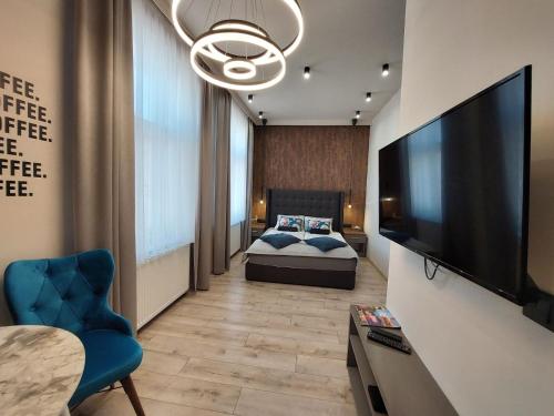 Silver Dawn Apartments في سيجد: غرفة نوم بسرير وتلفزيون بشاشة مسطحة