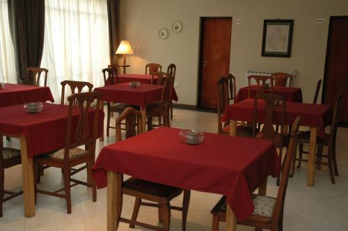 una sala da pranzo con tavoli e sedie rossi di Como era Antes a Victoria