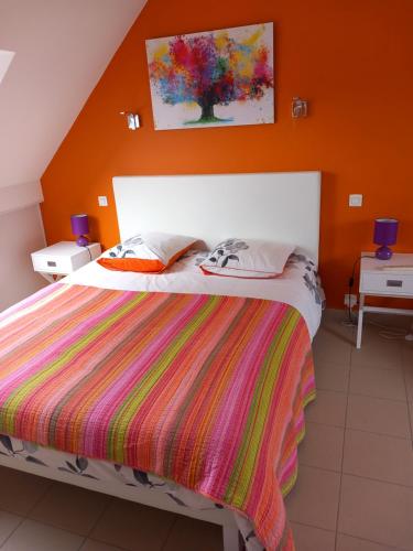 ein Schlafzimmer mit einem Bett mit einer orangefarbenen Wand in der Unterkunft Auprès de mon arbre in Saint-Gildas-de-Rhuys