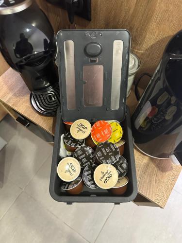 un récipient de boutons sur une table à côté d'une cafetière dans l'établissement MISIC HOME, à Colmar