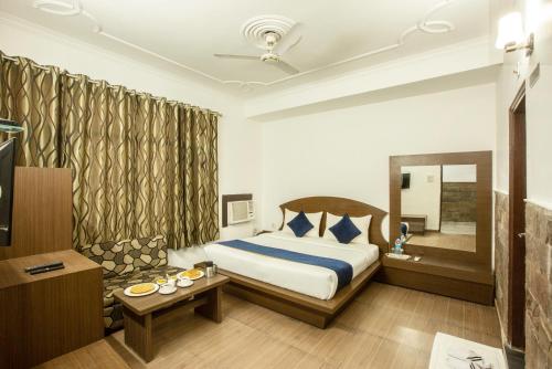 a hotel room with a bed and a mirror at Hotel Katra Residency in Katra
