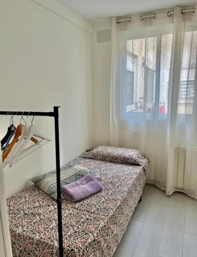 2 Betten in einem Zimmer mit Fenster in der Unterkunft Apartamento Cuidad Ciencias in Valencia