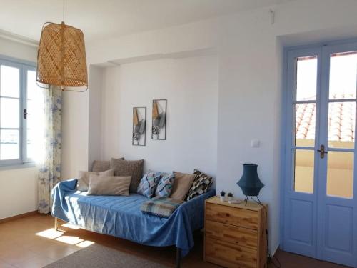 um quarto com uma cama com lençóis azuis e um cobertor azul em Aegina Port Apt 2-Διαμέρισμα στο λιμάνι της Αίγινας 2 em Egina